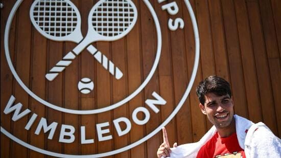 Spain's Carlos Alcaraz shows a Wimbledon sign as he leaves court after warming up during the 2025 Wimbledon Championships at The All England Lawn Tennis and Croquet Club in Wimbledon, southwest London, on June 29, 2025. (Photo by HENRY NICHOLLS / AFP) / RESTRICTED TO EDITORIAL USE (AFP)